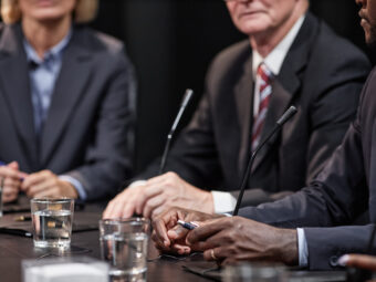 Hands of Black Man Sitting at Table while Speaking at Political Meeting